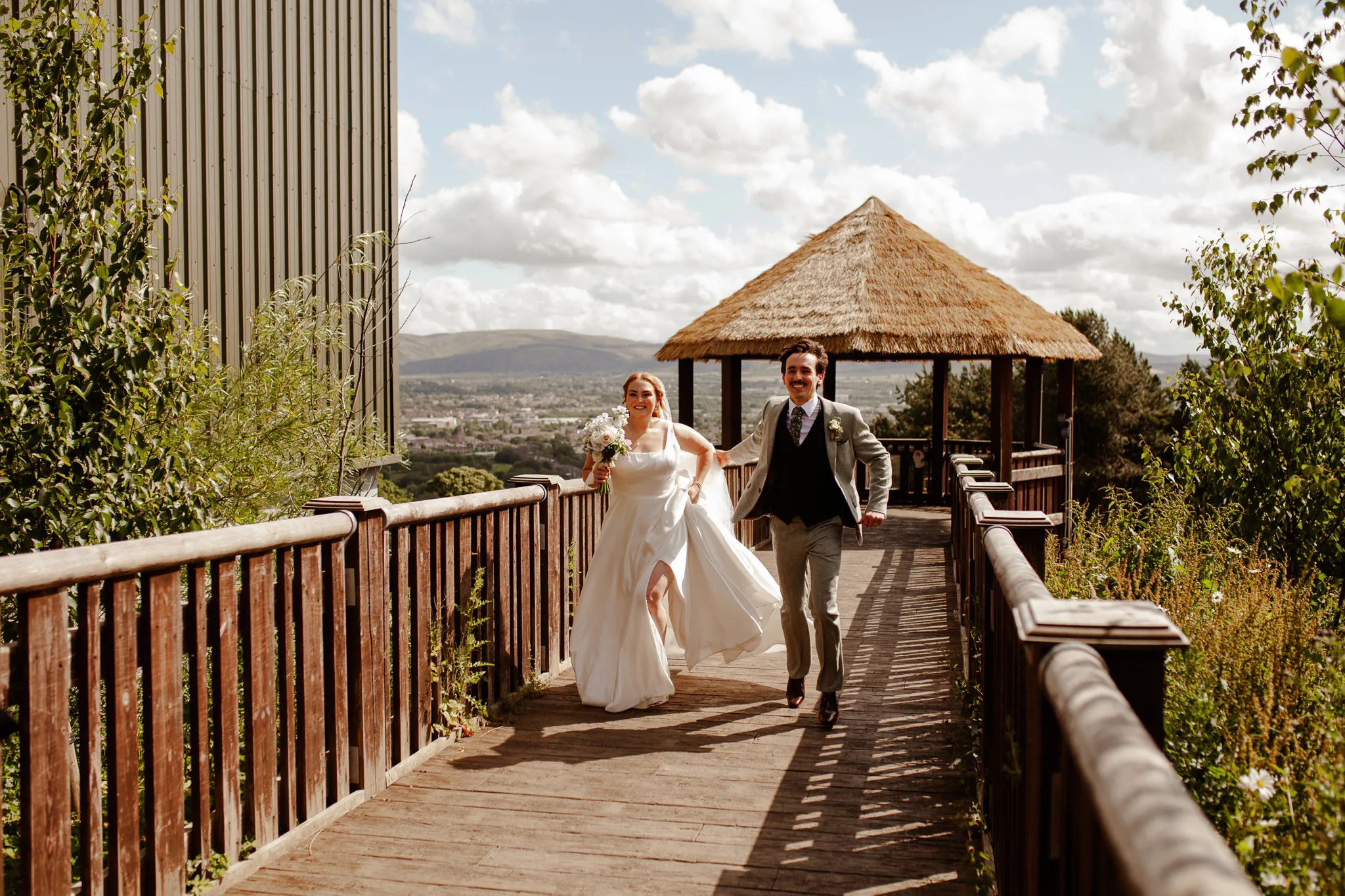 Couple smiling and walking at Edinburgh Zoo on their wedding day