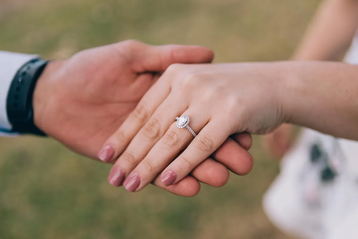 couple_holding_hands_wearing_engagement_ring