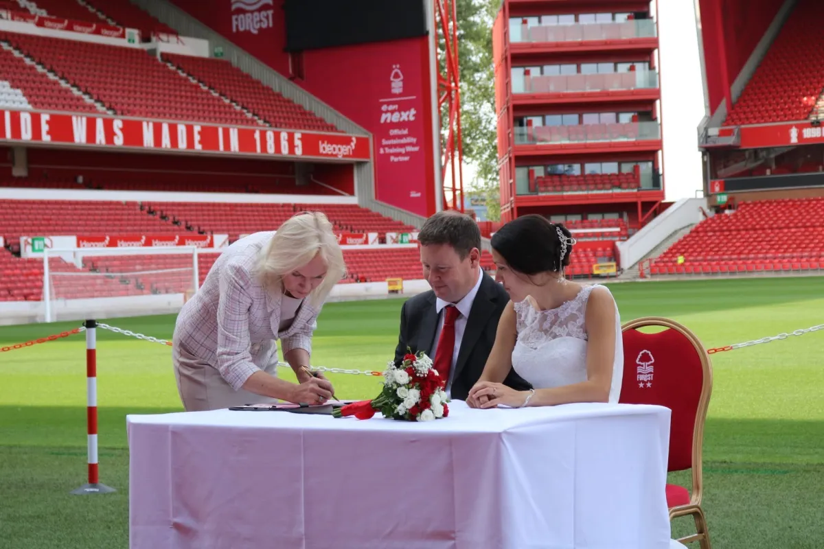 Couple signing their wedding certificate at a stadium
