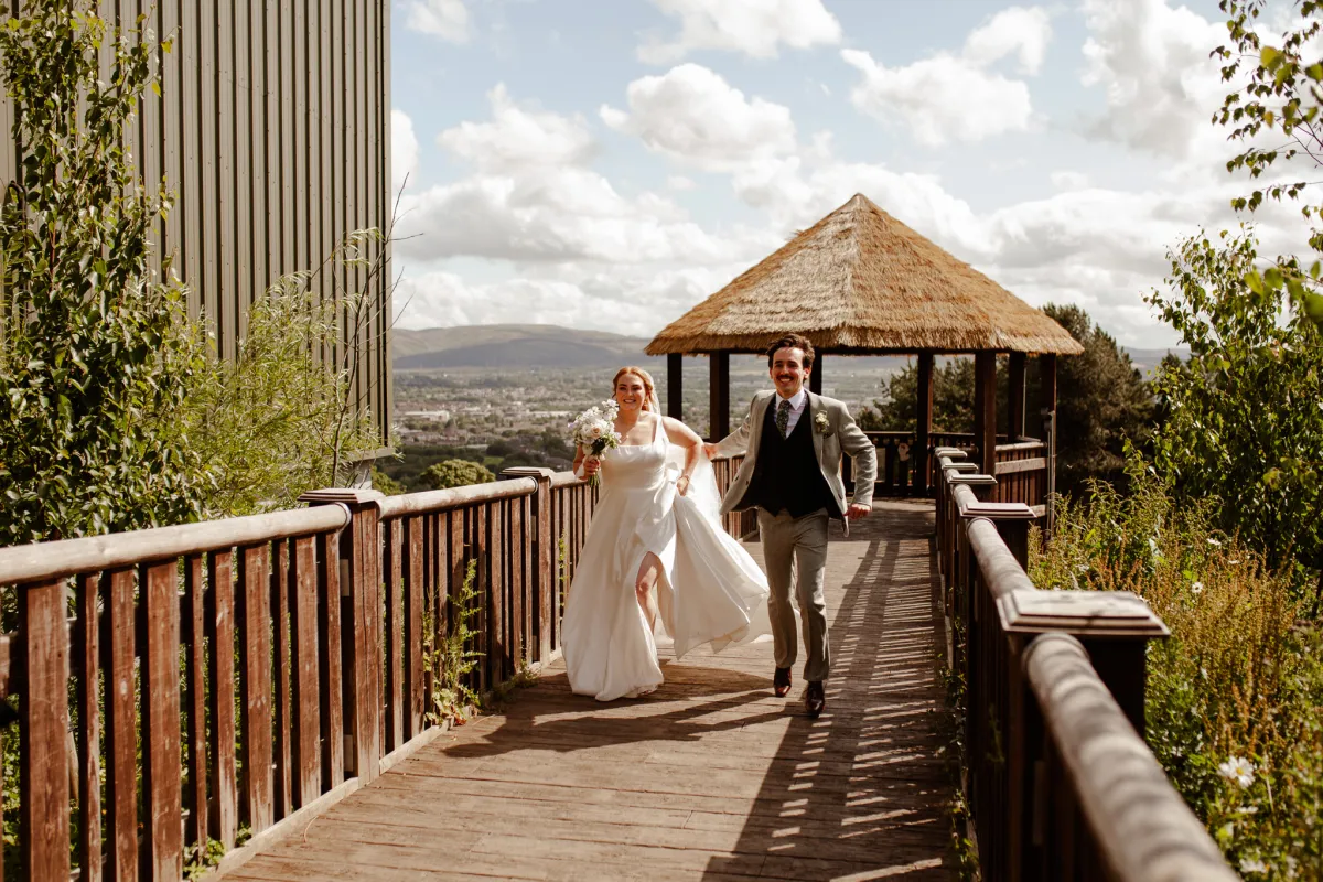 Couple smiling and walking at Edinburgh Zoo on their wedding day