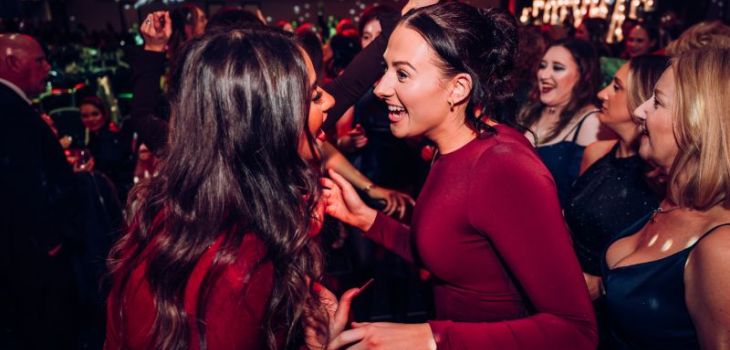 People dancing and talking at an event at Emirates Old Trafford