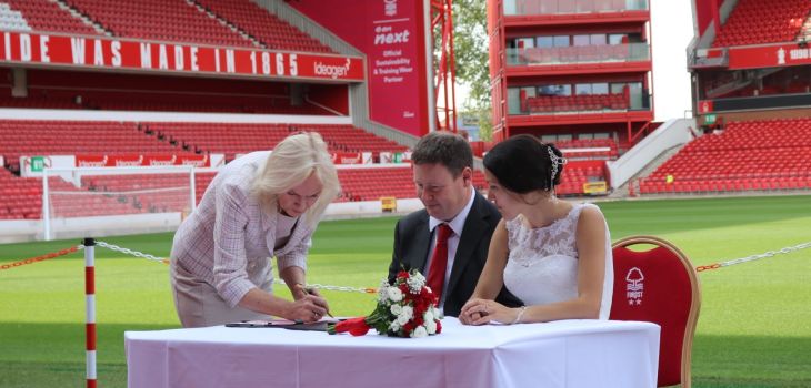 Couple signing their wedding certificate at a stadium