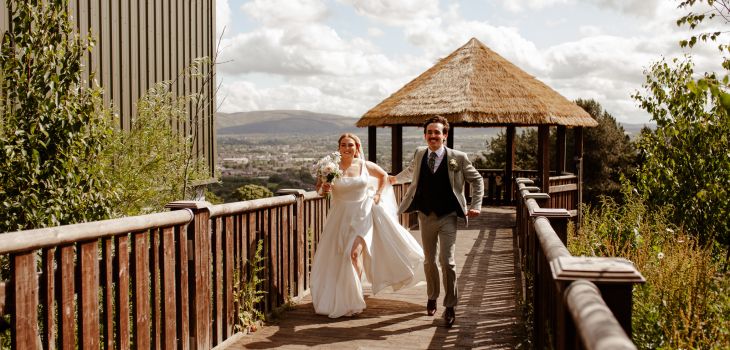 Couple smiling and walking at Edinburgh Zoo on their wedding day
